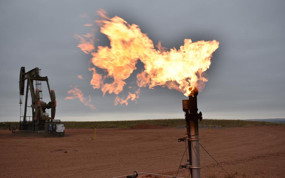 A flare burns natural gas at an oil well in Watford City, N.D., in 2021.