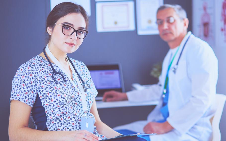 A medical team of doctors, man and woman, sitting in office