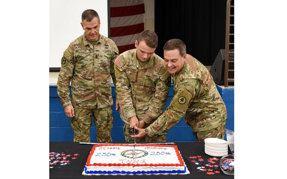 Tennessee's Senior Enlisted Leader, Command Sgt. Maj. Dale Crockett, looks on as Pfc. Christian Amacher and Col. Mark Phillips perform the ceremonial cake cutting during the Tennessee National Guard's 250th birthday celebration at Nashville's Joint Force Headquarters on August 16. (U.S. Army National Guard photo by retired Sgt. 1st Class Edgar Castro)