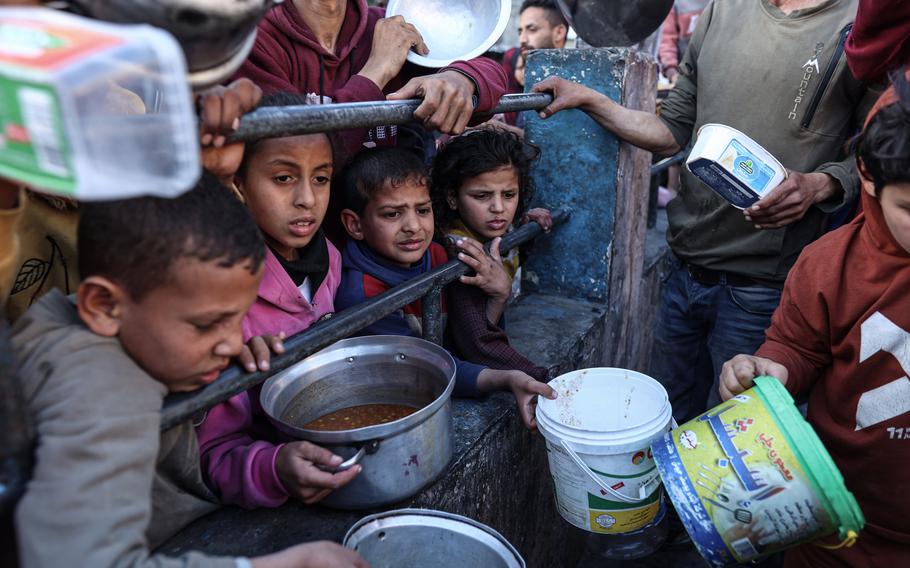 Displaced Palestinians gather to collect food donated by a charitable youth group on the second day of the holy month of Ramadan in Rafah on March 12. 