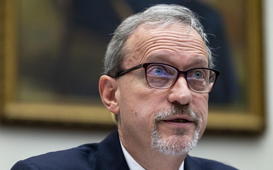 A close-up view of a man with dark-rimmed glasses testifying during a congressional hearing.