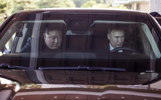 Russian President Vladimir Putin, right, and North Korean leader Kim Jong Un drive a Russian Aurus limousine during their meeting in Pyongyang on June 19, 2024.