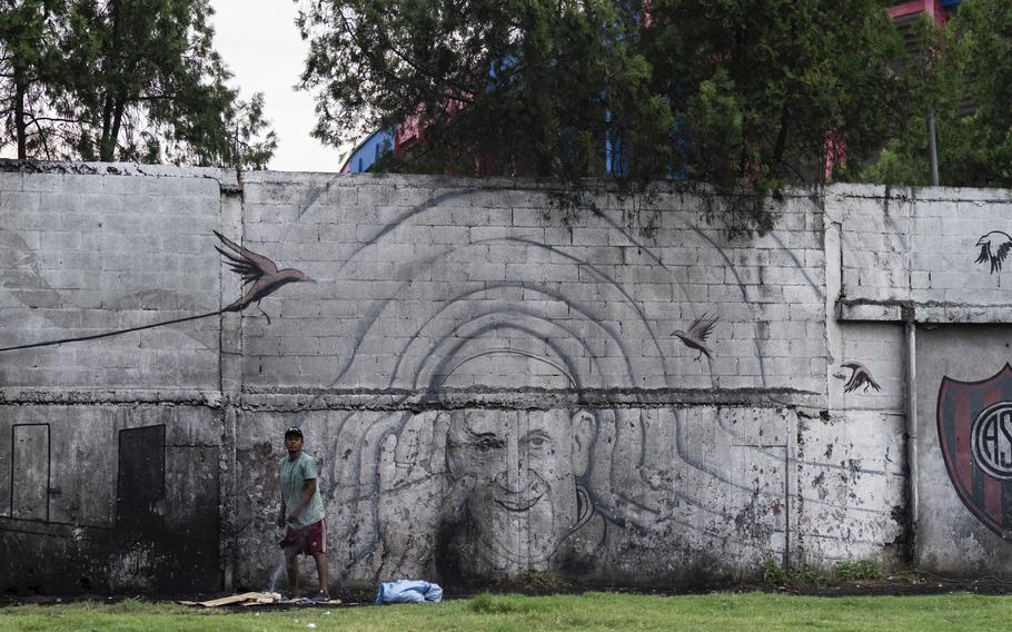 A man stands in front of a mural of Pope Francis outside the stadium of San Lorenzo, his soccer team, in the Padre Ricciardelli neighborhood of Buenos Aires, Argentina, Tuesday, Feb. 25, 2025. 