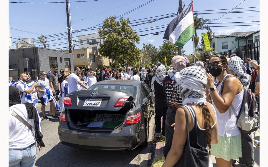 Pro-Palestine protester gets in car that is being swarmed by Pro-Israel protesters near Adas Torah on West Pico Boulevard on June 23, 2024, in Los Angeles. 