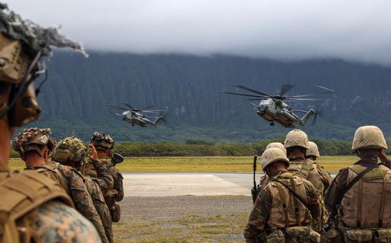 U.S. Marines assigned to Charlie Company, Battalion Landing Team 1/5, 15th Marine Expeditionary Unit, left, and Tongan marines assigned to His Majesty’s Armed Forces prepare to retrograde in CH-53E Super Stallions attached to Marine Medium Tiltrotor Squadron (VMM) 165 (Reinforced), 15th MEU, after an amphibious raid exercise at Marine Corps Training Area Bellows, Waimanalo, Hawaii, as part of Exercise Rim of the Pacific 2024, July 27. Twenty-nine nations, 40 surface ships, three submarines, 14 national land forces, more than 150 aircraft and 25,000 personnel are participating in RIMPAC in and around the Hawaiian Islands, June 27 to Aug. 1. The world's largest international maritime exercise, RIMPAC provides a unique training opportunity while fostering and sustaining cooperative relationships among participants critical to ensuring the safety of sea lanes and security on the world's oceans. RIMPAC 2024 is the 29th exercise in the series that began in 1971. (U.S. Marine Corps photo by Cpl. Aidan Hekker)