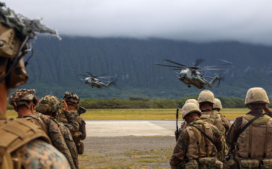 U.S. Marines assigned to Charlie Company, Battalion Landing Team 1/5, 15th Marine Expeditionary Unit, left, and Tongan marines await CH-53E Super Stallions after an amphibious raid exercise at Marine Corps Training Area Bellows, Waimanalo, Hawaii, as part of Exercise Rim of the Pacific, July 27, 2024. 