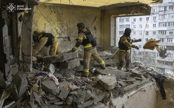 In this photo provided by the Ukrainian Emergency Service, rescuers search for civilians who were killed when a Russian drone hit an apartment building in Sumy, Ukraine, Thursday, Jan. 30, 2025. (Ukrainian Emergency Service via AP)