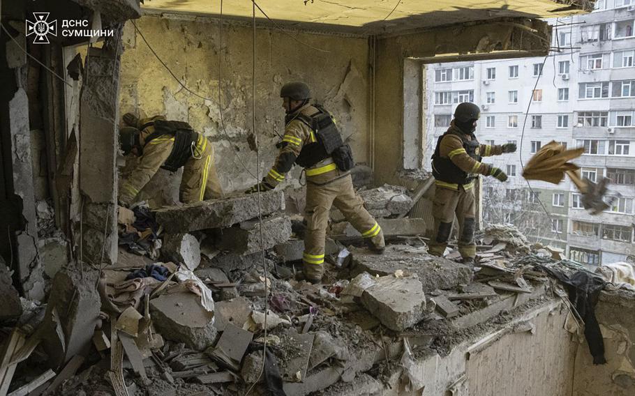 Rescuers search for civilians who were killed when a Russian drone hit an apartment building