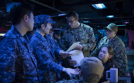 U.S. and Japanese sailors discuss Tomahawk missile procedures aboard the guided-missile destroyer USS McCampbell during training at Yokosuka Naval Base, Japan, on March 28, 2024. 