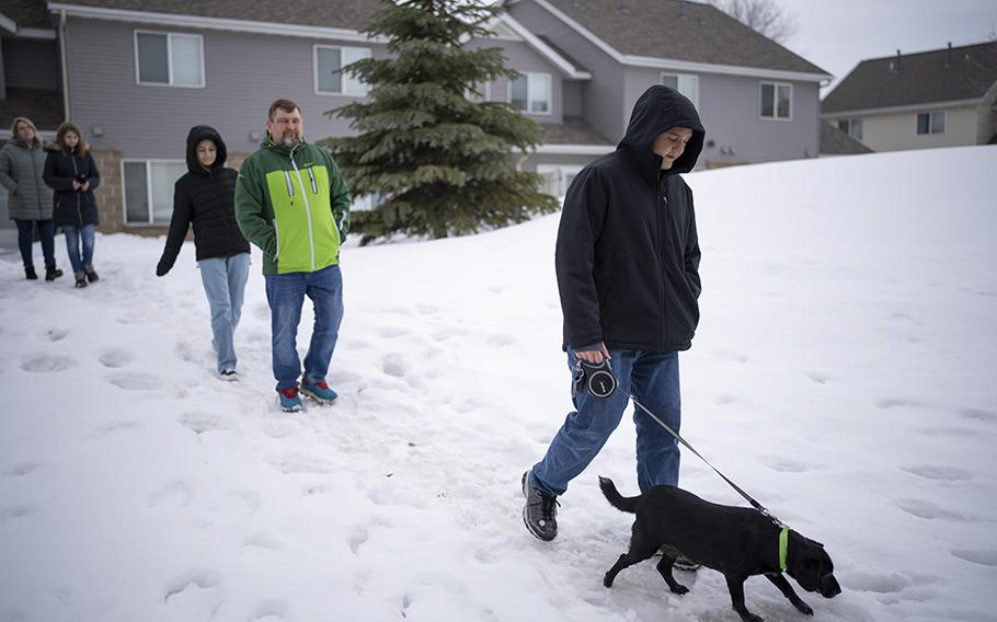 Kirill, Artem, Polina, Dasha, and Katya, from right, take their dog, Ulya, for a walk around their neighborhood in Shakopee, Minnesota. 