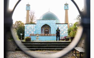 A police officer stands outside the Islamic Center Hamburg with the Imam Ali Mosque during a raid Wednesday, July 24, 2024, Hamburg, Germany. (Daniel Bockwoldt/dpa via AP)
