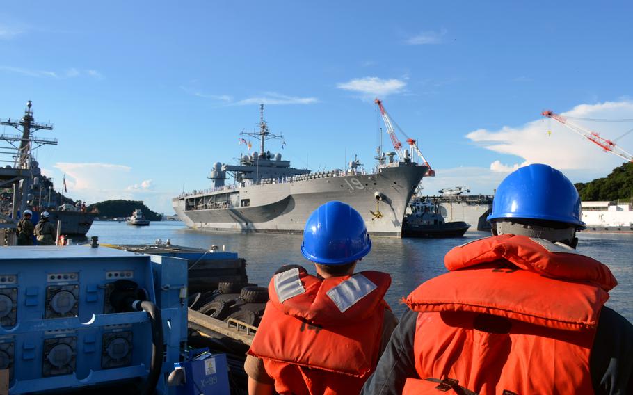 Sailors standby on Pier 9 to help moor the USS Blue Ridge at Yokosuka Naval Base, Japan, Tuesday, Aug. 20, 2024. 