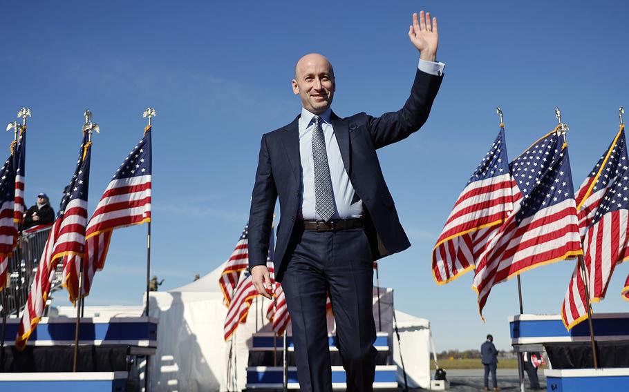 Stephen Miller waves to the crowd as he walks on stage during a campaign rally.