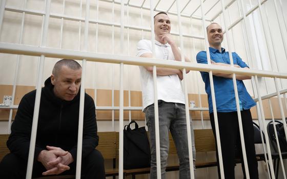 Former Navalny's lawyers Igor Sergunin, left, Alexei Liptser, center, and Vadim Kobzev, right, appear in the cage during a court session in Petushki, Vladimir region, about 120 kilometers (75 miles) east of Moscow, Russia, Thursday, Sept. 12, 2024. (AP Photo/Alexander Zemlianichenko)