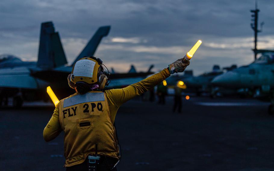 Petty Office 2nd Class Nadia Chapel, an aircraft handler on the USS Ronald Reagan, directs an F/A-18F Super Hornet during a Valiant Shield drill in the Philippine Sea, June 9, 2024.