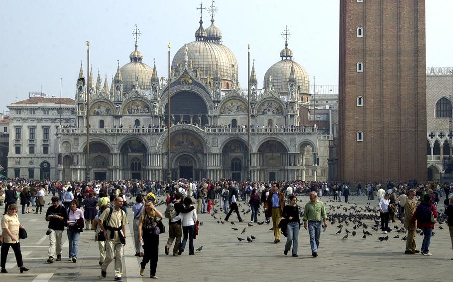 Tourists walk across St Mark's Square in Venice, Italy. The city is charging day-trippers a 5-euro tax on certain days in an effort to curb overtourism. U.S. military families stationed in Vicenza can request an exemption from the tax.