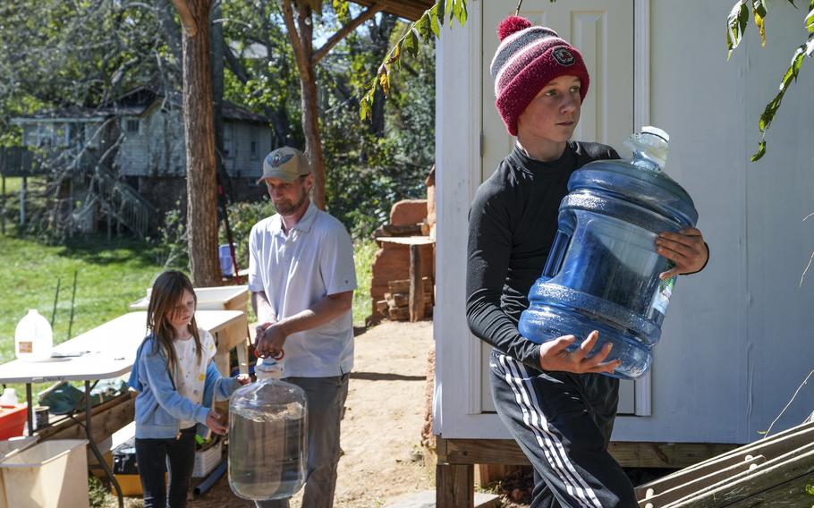 McCullough Hager, 12, carries one of the jugs of purified water