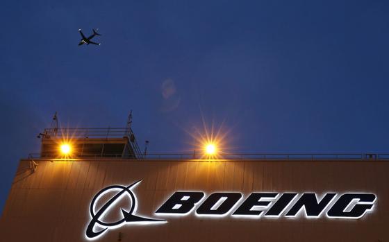 FILE - An airplane flies over a sign on Boeing's newly expanded 737 delivery center, Oct. 19, 2015, at Boeing Field in Seattle. The U.S. Justice Department plans to propose that Boeing plead guilty to fraud in connection with two deadly plane crashes involving its 737 Max jetliners, according to two people who heard federal prosecutors detail the offer Sunday, June 30, 2024. (AP Photo/Ted S. Warren, File)
