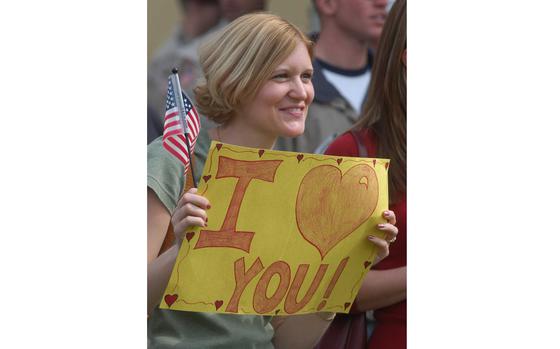 Vicenza, Italy, Mar. 30, 2006: Jen Dean holds the American flag and a sign that says it all as she greets her husband Capt. Joel Dean of 2nd Battalion, 503rd Infantry Regiment, 173rd Airborne Brigade, back to Vicenza, Italy. Dean and his fellow soldiers were returning from a year's deployment  to Afghanistan. 

META TAGS: U.S. Army; Army spouse; dependent; welcome home; military family