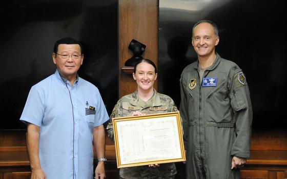 1st Lt. Regina Bean, of the 18th Operational Medical Readiness Squadron, poses with Kin Mayor Hajime Nakama and Col. Josh Lundeby, deputy commander of the 18th Wing, at Kadena Air Base, Okinawa, Jun. 6, 2024. Bean was honored for saving a motorcyclist's life in February. 