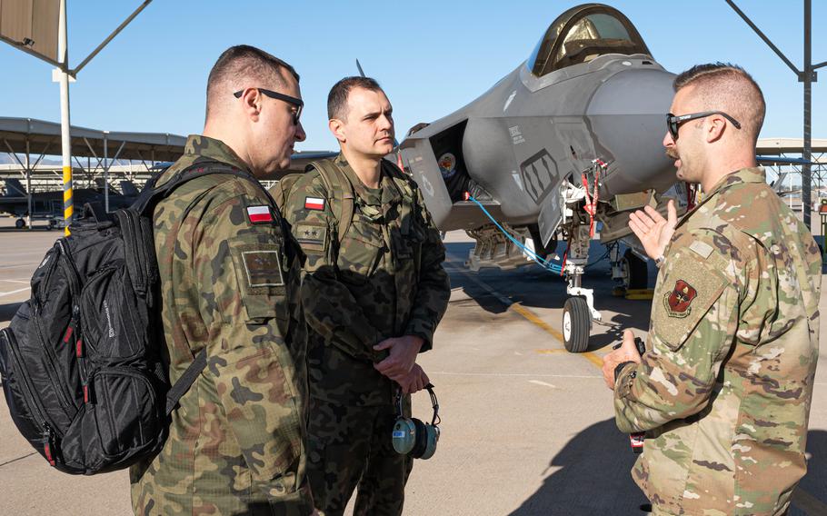U.S. Air Force Tech. Sgt. Raymond Lemmert, right, briefs Polish air force Lt. Col. Pawal Muzyczuk, left, and Lt. Col. Rafal Zawadka on F-35 maintenance operations in 2022 at Luke Air Force Base, Ariz. Poland will receive its second $2 billion loan from the U.S. in less than a year to modernize its armed forces with American weaponry.