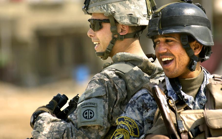 Spc. Frederick Lynds, a soldier from 82nd Airborne Division’s 2nd Battalion, 505th Parachute Infantry Regiment, jokes around with his Iraqi National Police counterpart after patrolling a nearby market in Oubaidy, Iraq.  