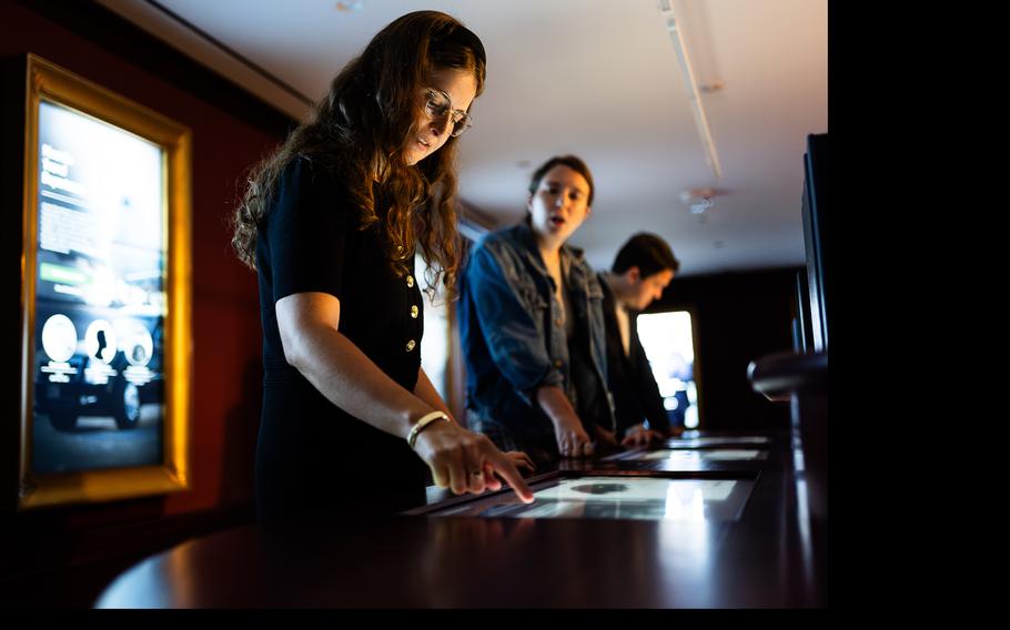 People interact with a responsive research table that explores the role and contributions of officials at the White House. 