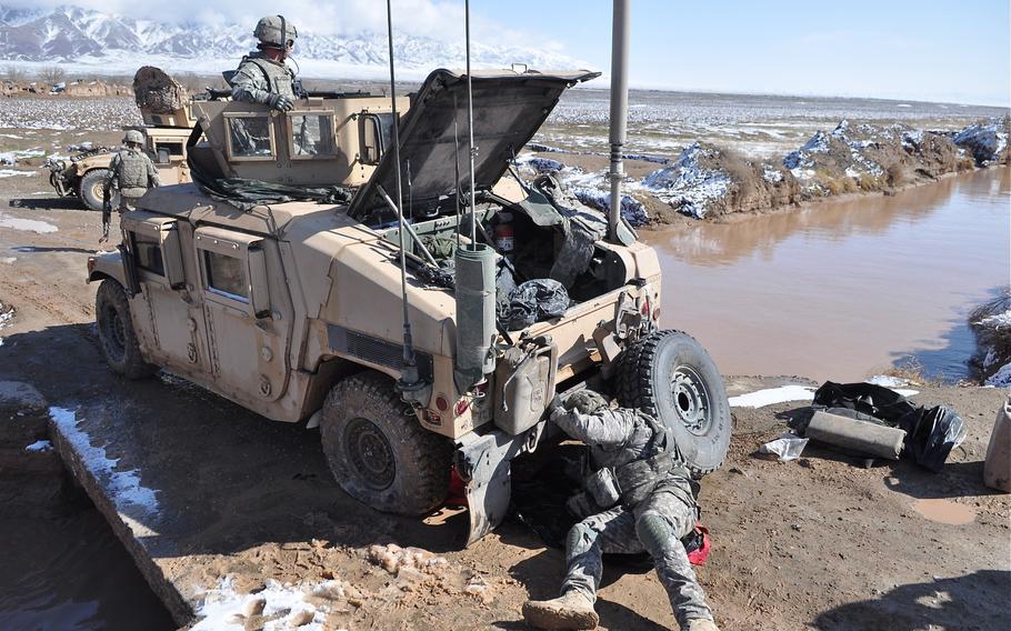 A U.S. soldier with the 82nd Airborne Division's 4th Squadron, 73rd Cavalry Regiment tends to a Humvee with a flat tire on Feb. 8, 2010. The soldiers were on a joint patrol with Afghan National Police in the Pashtun Zarghun district of Herat province in western Afghanistan.