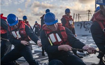 Sailors aboard the USS William P. Lawrence heave the line attached to a fuel probe from the USS Carl Vinson in a refueling evolution during RIMPAC exercises in Hawaii on July 21, 2024.