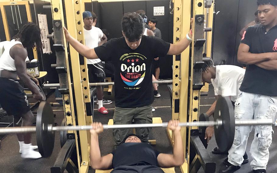 Humphreys' Marvin Gibson lifts while quarterback Bradley Miller watches over him.