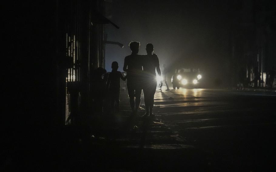 Residents walk on a street during a blackout