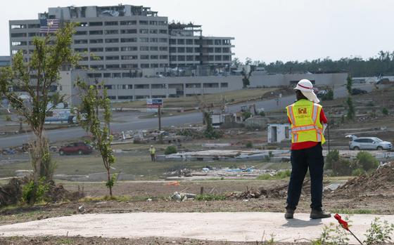 Bob Hill, a heavy mobile equipment mechanic with the U.S. Army Corps of Engineers' Philadelphia District, surveys the tornado-stricken landscape of the city during a break in debris removal operations here July 24. Hill is one of more than 300 Corps employees who've volunteered to support federal recovery operations after an EF-5 tornado ripped through the city May 22. More than 8,000 commercial and residential buildings were damaged or destroyed, including St. John's Regional Medical Center, visible in the background. The Federal Emergency Management Agency tasked the Corps with removing debris from public rights of way and some residential properties, constructing temporary critical facilities such as schools and fire stations, and building temporary housing parks.