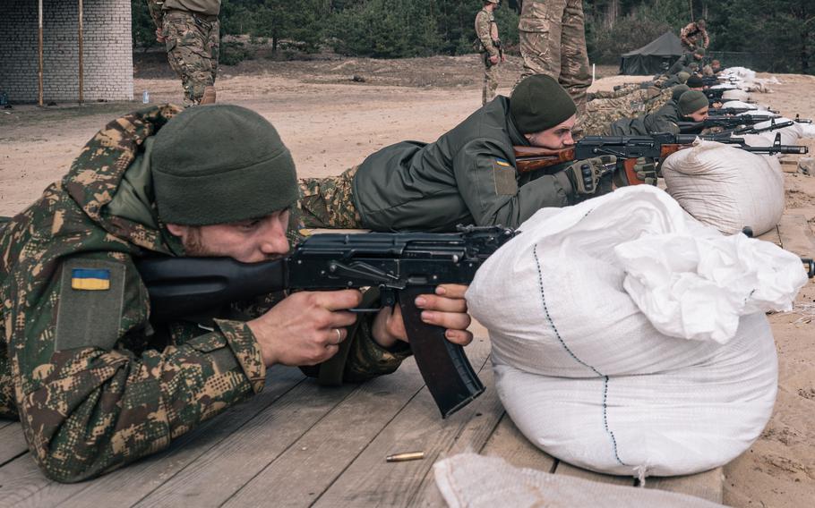 Ukrainian military recruits shoot on a firing range at an Azov Brigade training camp outside Kyiv in March 2023.