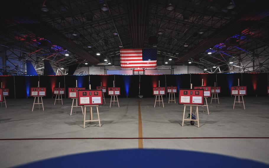 Plaques are displayed on easels in a hangar during a ceremony at RAF Lakenheath.