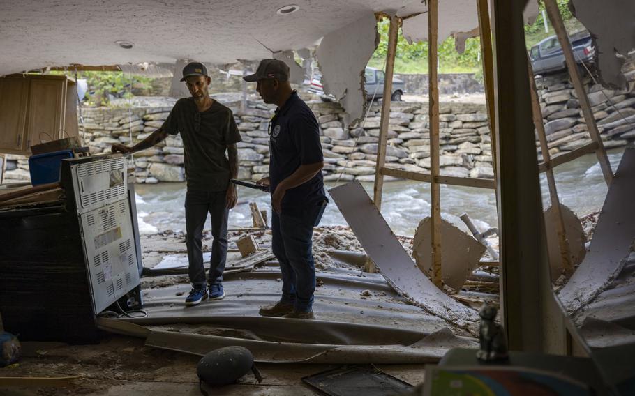 FEMA employee Jirau Alvaro works with Daniel Mancini, doing a report on the damage to his property