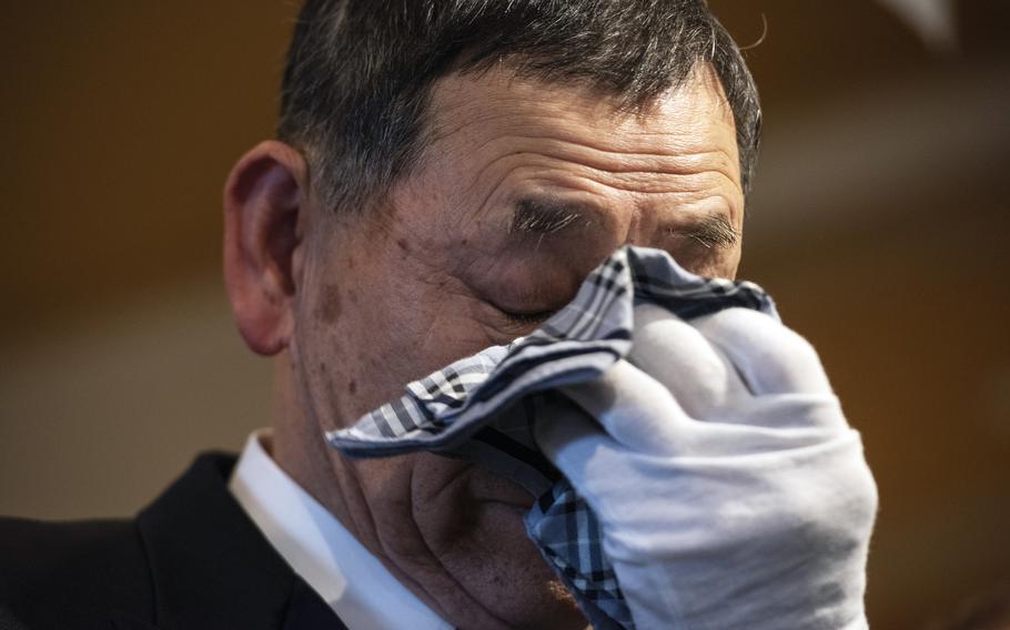 Ken Kudo wipes away tears with a handkerchief.