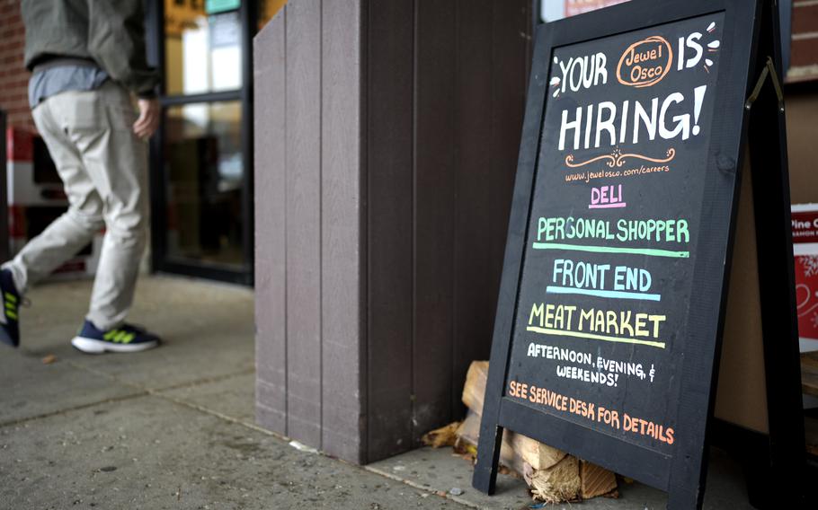 A sign for a store announces it is hiring.