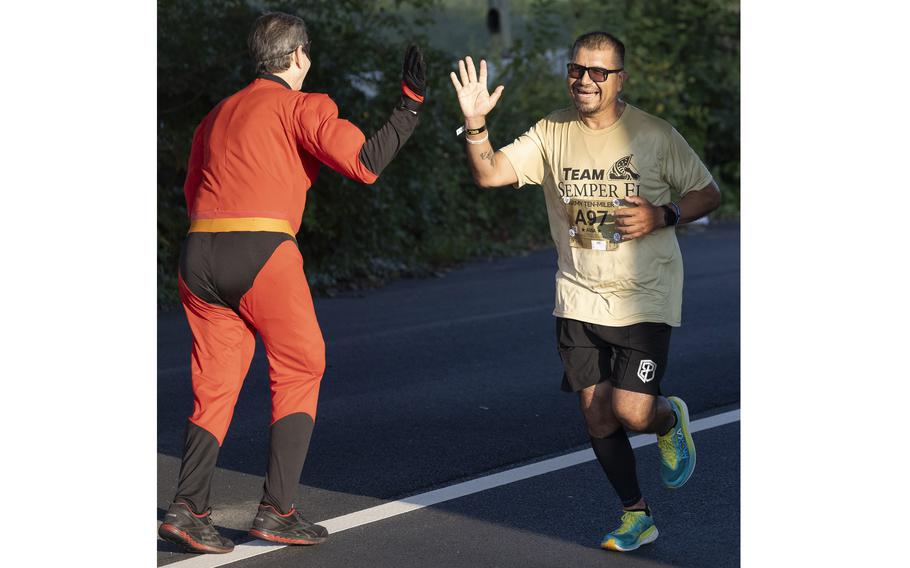 Runner high fives a volunteer as he runs by