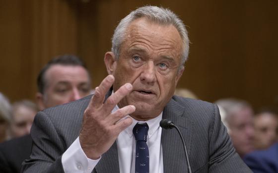 Robert F. Kennedy, Jr. speaks into a microphone with one hand raised in gesture.