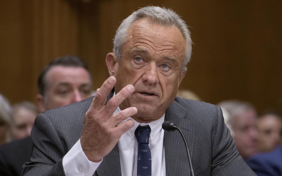 Robert F. Kennedy, Jr. speaks into a microphone with one hand raised in gesture.