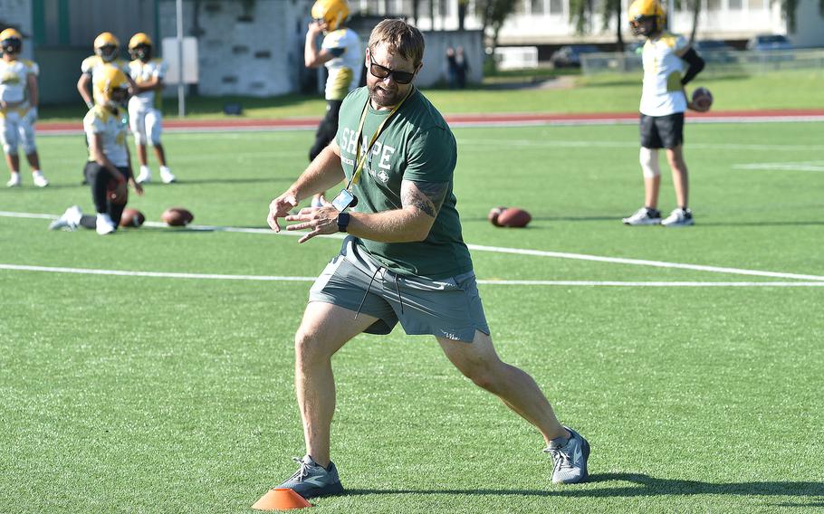 SHAPE football coach Jason Neago demonstrates how to break out of a cut during a drill at an Aug. 27, 2024, practice in Mons, Belgium.