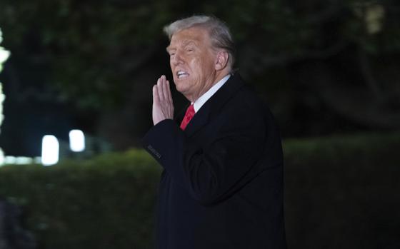 President Trump raising a hand up while he speaks.