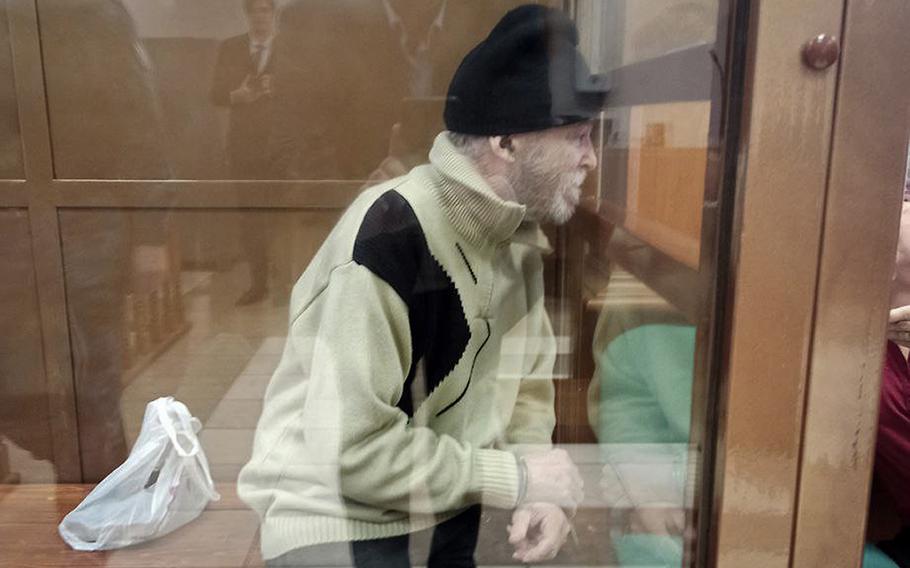 Stephen Hubbard sits in a glass cage during a court session in Moscow.