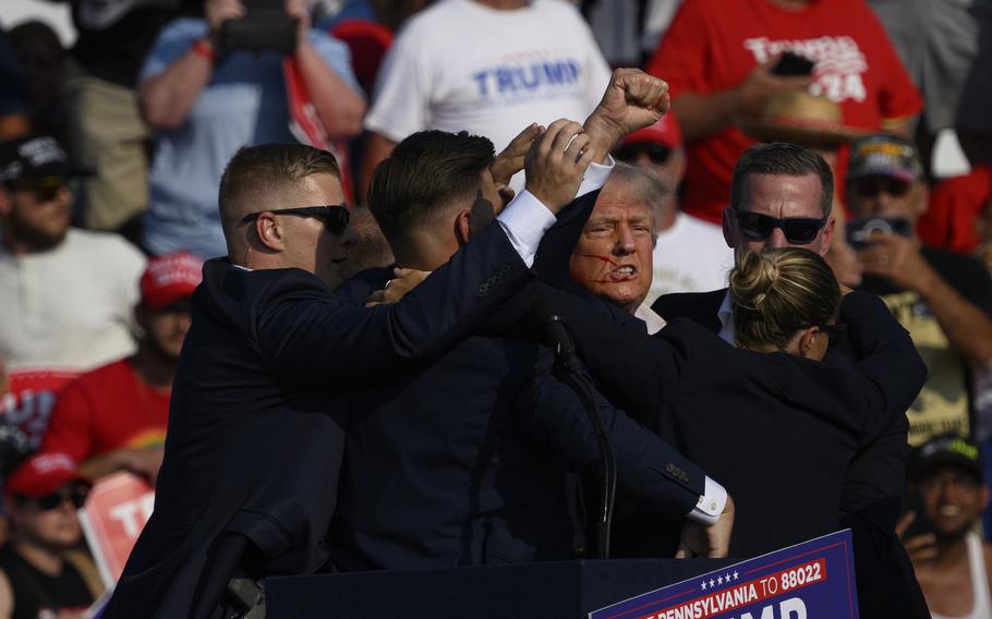 Former president Donald Trump is whisked away by Secret Service after shots rang out at a campaign rally on July 13, 2024, in Butler, Pa. 