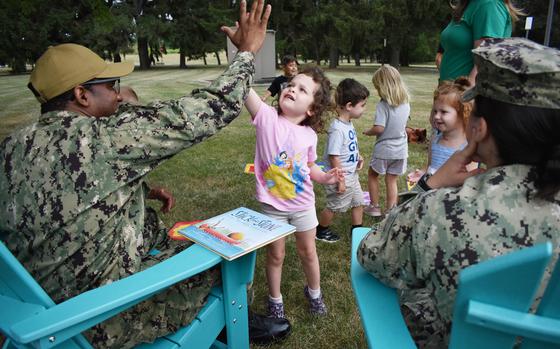 Lt. Cmdr. Lauren Elkins, assistant public works officer aboard Naval Support Activity Mechanicsburg, and Command Master Chief Daniel Hemingway II high-five preschoolers at the Child Development Center July 30 in observance of International Day of Friendship.