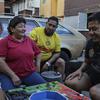 Men and women in Mexico City playing the board game poleana next to a car. 