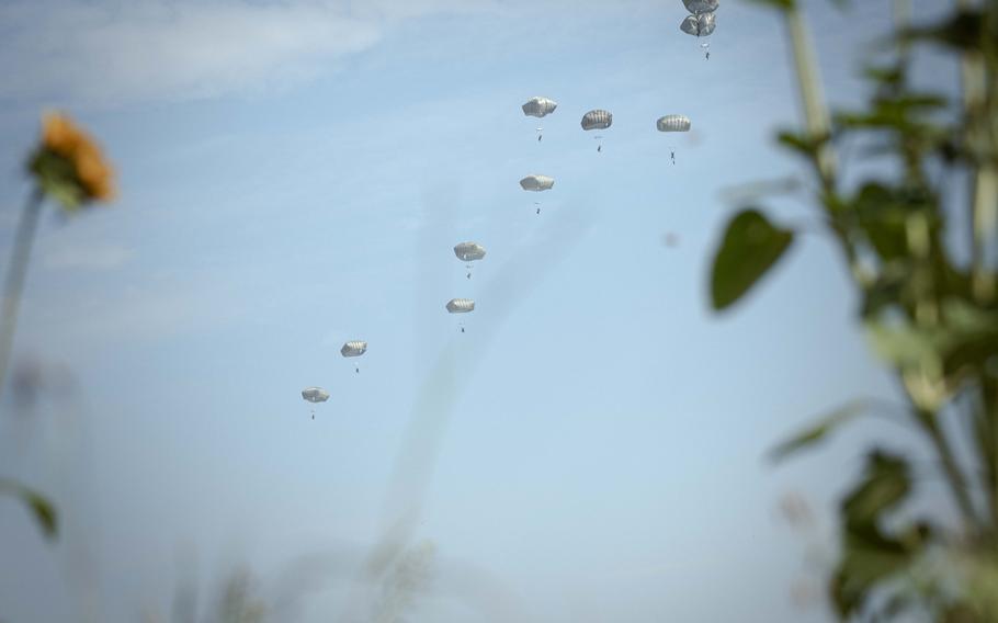 Army soldiers with the 173rd Airborne Brigade parachute into a field outside of the Joint Multinational Readiness Center Hohenfels Training Area for Exercise Saber Junction on Sept. 4, 2024.