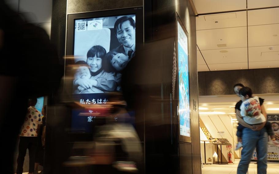 Tokyo Station commuters pass video ads featuring the family of North Korean abductee Megumi Yokota on Aug. 21, 2024.