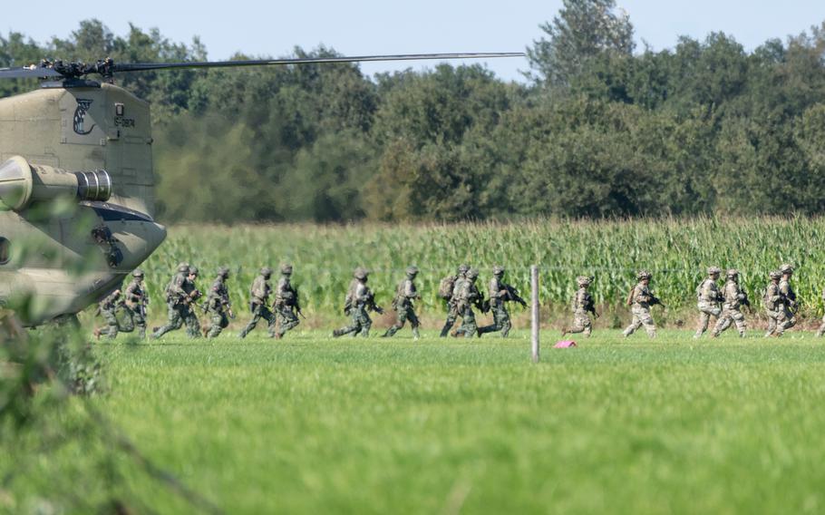 U.S. and Dutch troops file out of a Chinook aircraft 