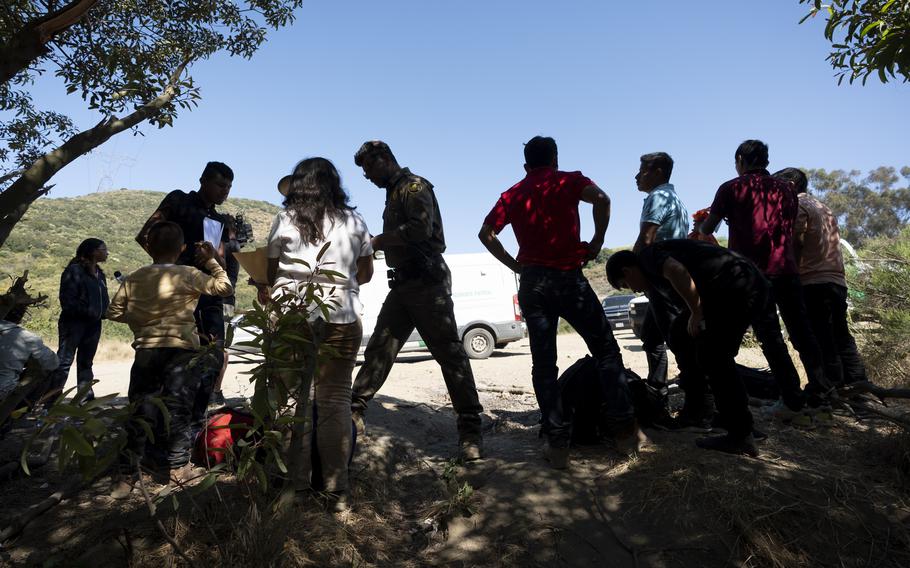 Border Patrol agents talk with migrants